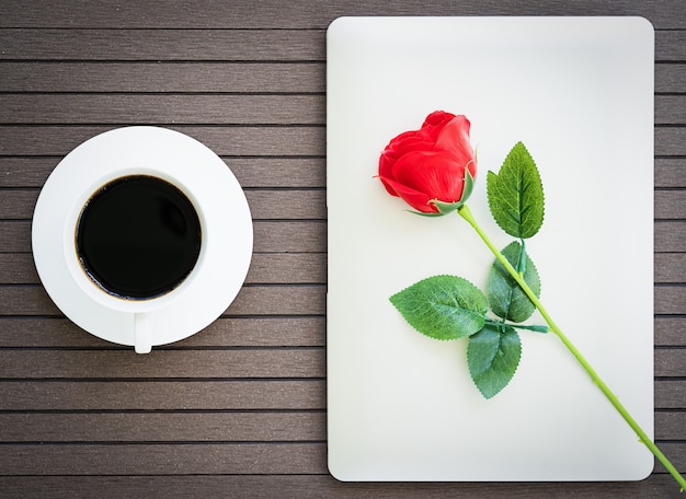 Tiempo de café con laptop, taza de café, rosa roja.