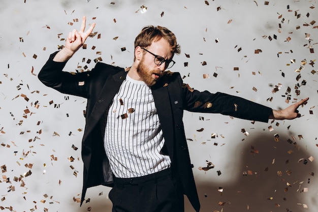 Tiempo de celebración Retrato de un chico feliz bailando bajo confeti brillante