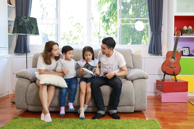 Tiempo completo de padre e hija sentados en el sofá