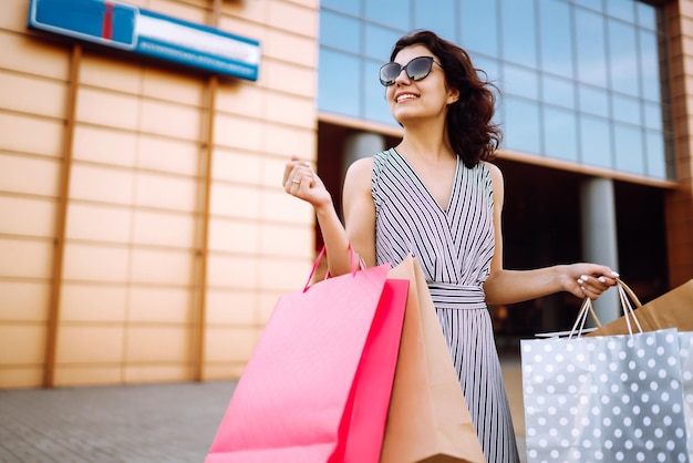 Tiempo de compras Mujer joven con bolsas de compras cerca del centro comercial Compras de venta de consumismo