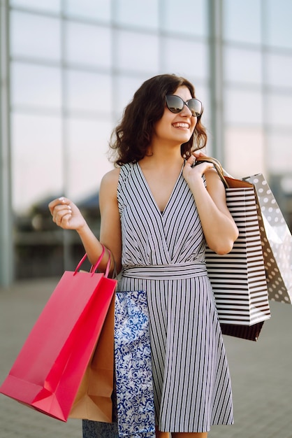 Tiempo de compras Mujer joven con bolsas de compras cerca del centro comercial Compras de venta de consumismo