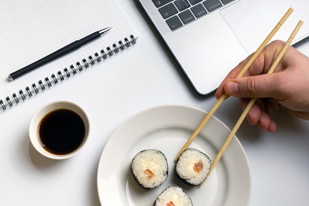 Tiempo de descanso para comer sushi. Rollos de sushi comiendo en el trabajo.