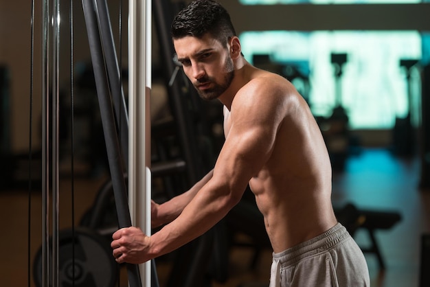 Tiempo de descanso confiado joven musculoso descansando en el gimnasio del club saludable después de hacer ejercicio