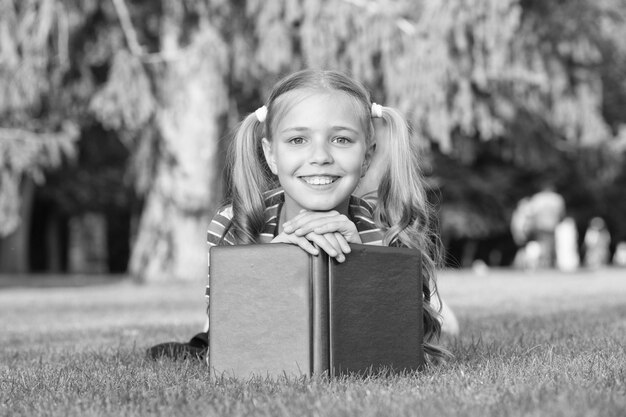 Tiempo escolar Desarrollando aprendices solidarios que están creciendo y logrando activamente Niño pequeño leyendo un libro Adorable ratón de biblioteca Colegiala leyendo historias relajante césped verde Lindo alumno disfruta leyendo