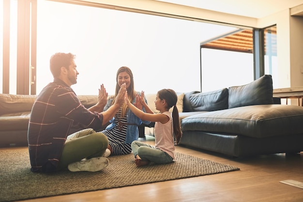 Foto el tiempo en familia es aún mejor cuando te diviertes foto de una familia feliz de tres personas jugando un juego de aplausos juntos en casa