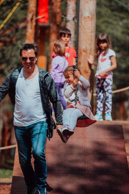 Tiempo en familia en el parque. El padre se divierte con su hija en el parque, juega juegos divertidos y pasa tiempo juntos.