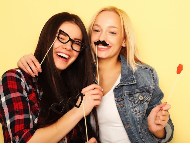 Tiempo feliz Chicas hipster sexy con estilo mejores amigas listas para la fiesta Sobre fondo amarillo