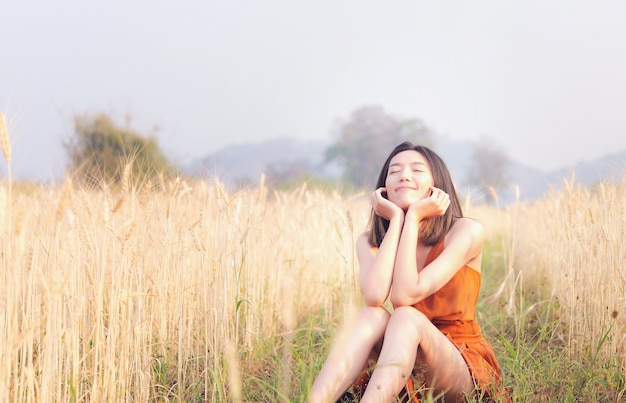 Tiempo feliz mujer asiática en campo de cebada