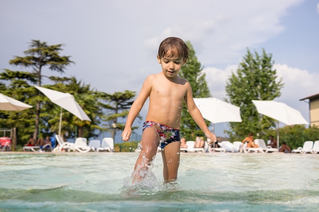 Tiempo feliz para los niños de diversión y disfrute en la piscina de verano