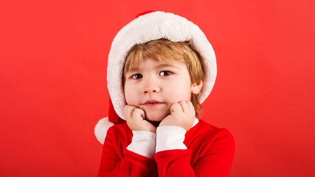 Tiempo de Navidad. Niño disfrazado de Santa. Niño lindo con sombrero de Santa. Vacaciones de año nuevo.