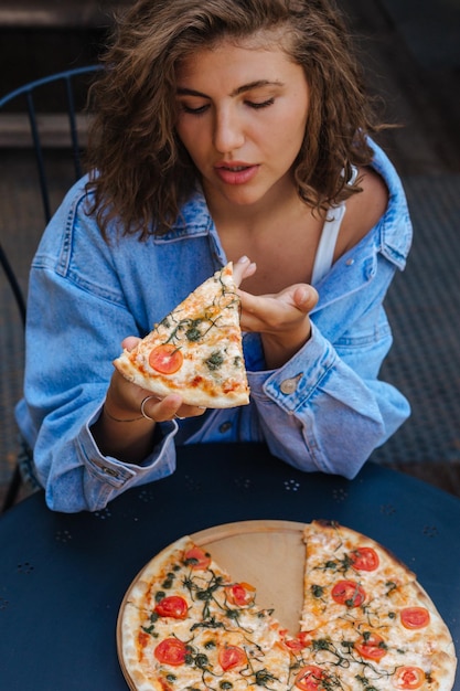 Tiempo de pizza Mujer muy sonriente comiendo pizza en el restaurante