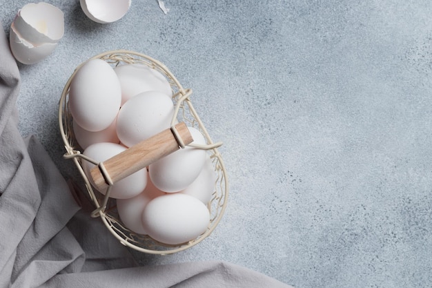 Tiempo de primavera vacaciones de pascua huevos blancos en una mesa de cesta gris