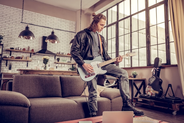 Tiempo de rock. Participante de la famosa banda de rock moderno con ensayo en la sala de estar