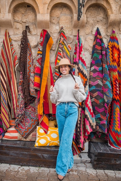 Tienda de alfombras turcas tradicionales antiguas en casa cueva capadocia turquía kapadokya mujer joven en vacatio ...