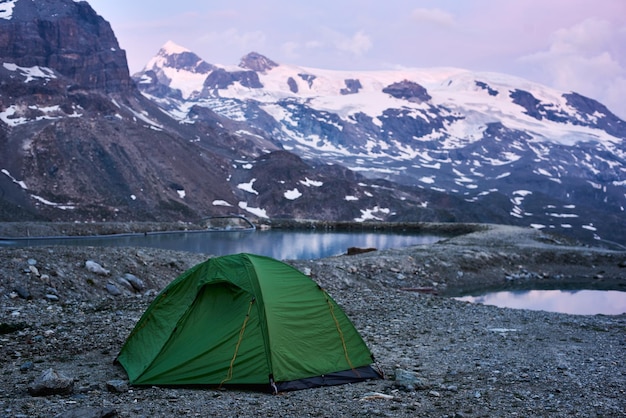 Tienda de campaña cerca del pequeño lago de montaña