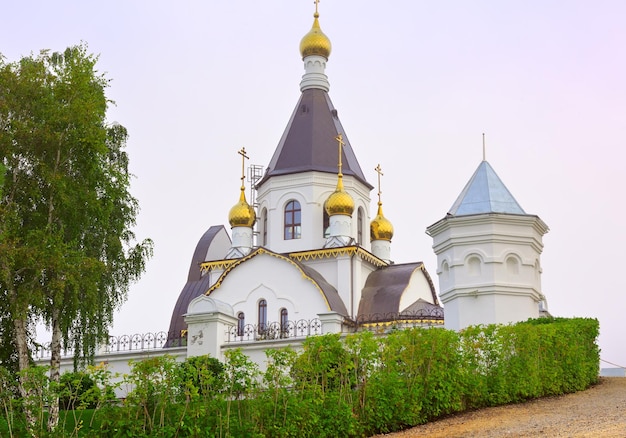 Tienda de campaña de la iglesia ortodoxa detrás de la valla del monasterio en una mañana brumosa Krasnoyarsk, Siberia, Rusia