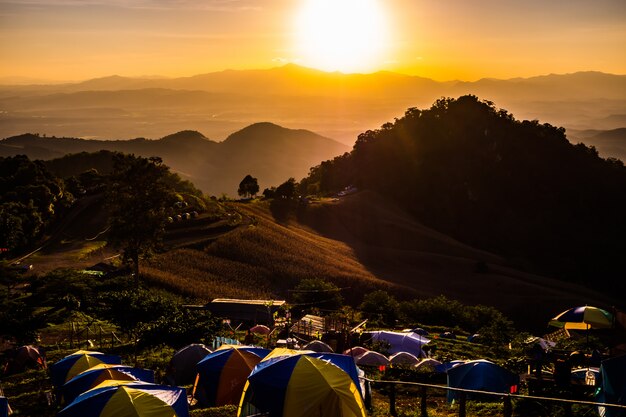 Tienda de campaña en la puesta de sol con vistas a las montañas