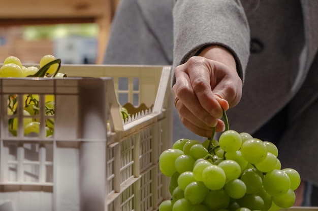 En una tienda de comestibles una mujer recoge uvas