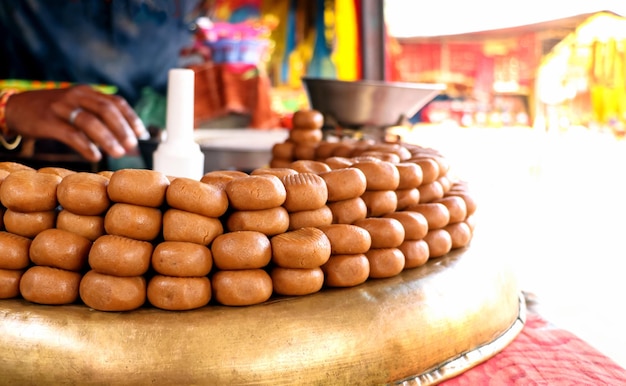 La tienda de dulces india muestra peda o pera fuera del templo