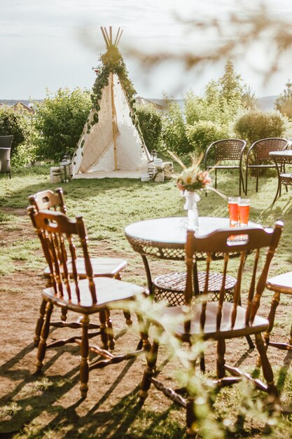 Tienda india de tela de madera decorada con ramas de eucalipto verde en el patio trasero, evento o boda en estilo boho