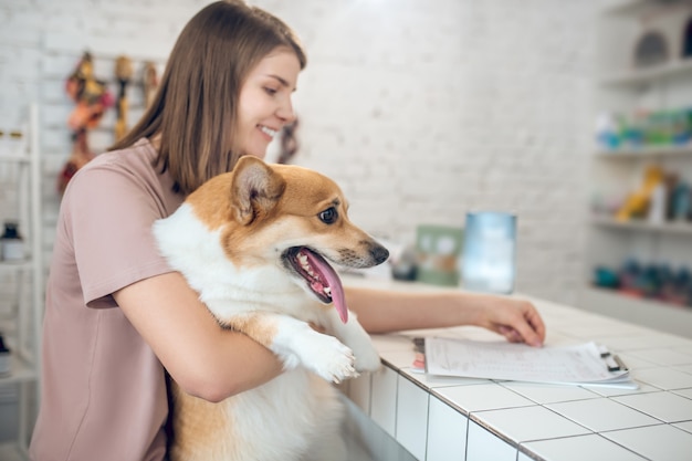 En una tienda de mascotas. Linda chica joven con su perro pasar tiempo en una tienda de mascotas