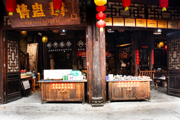 Tienda de regalos de recuerdos locales en el mercado callejero para el pueblo chino viajeros visita de compras en el edificio histórico arquitectura antigua de Furong Zhen Tujia ciudad antigua el 9 de mayo de 2024 en Hunan China