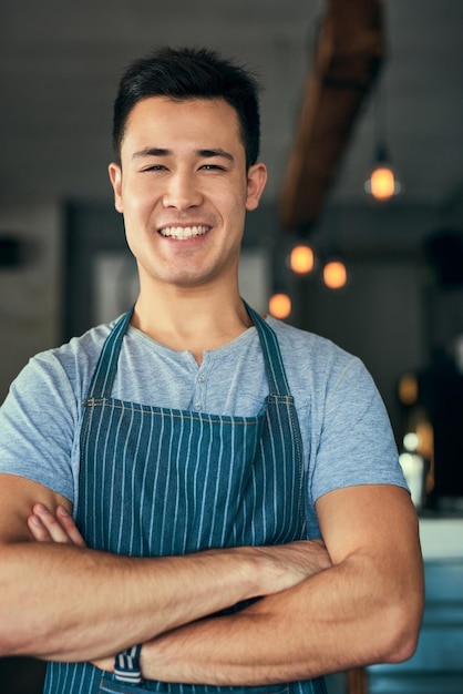 Tiene confianza en su cafetería Retrato recortado de un joven de pie con los brazos cruzados en su cafetería