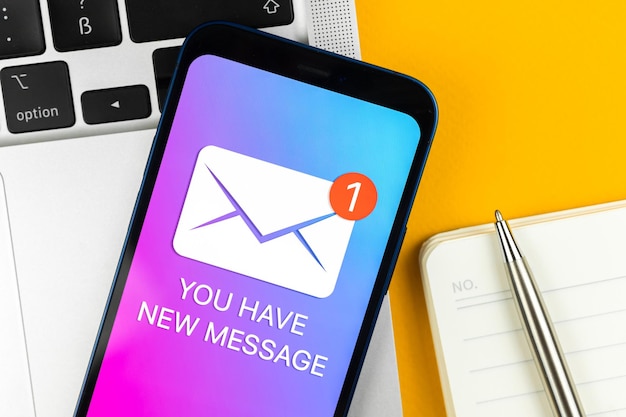 Tiene una nueva notificación de texto de mensaje en una pantalla de teléfono móvil vista de primer plano Concepto de comunicación empresarial portátil y foto de fondo de mesa de oficina