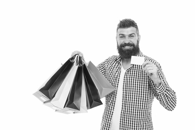 Tiene una tarjeta de fidelización Hombre barbudo sonriendo con tarjeta de descuento y bolsas de papel aisladas en blanco Hombre de negocios feliz mostrando tarjeta en blanco para información comercial Pagando con espacio de copia de tarjeta de crédito