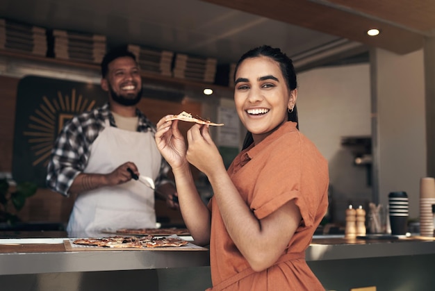 Tienes que probar este lugar Foto de una mujer joven y atractiva de pie y disfrutando de una pizza recién hecha en un restaurante