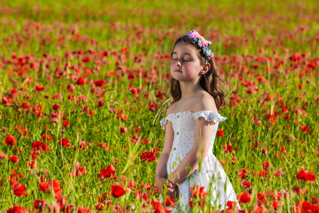 Tierna chica en vestido en prado de flores