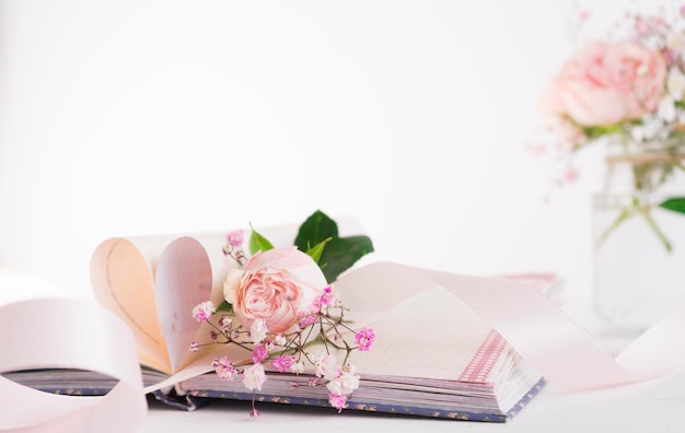 Un tierno capullo de rosa se encuentra en un libro Imagen con enfoque selectivo