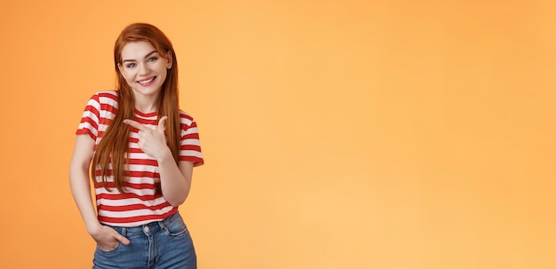 Tierno lindo femenino pelirroja encantadora chica inclinar la cabeza sonriendo alegremente hacia la izquierda mostrando el camino dar