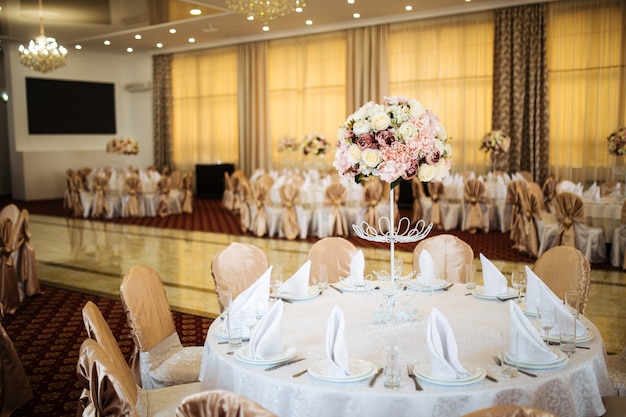 Tierno ramo de flores rosadas en la mesa del banquete servido