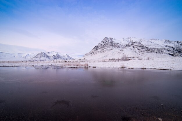 Tierras y montañas cubiertas de nieve escénica en Islandia durante el invierno.