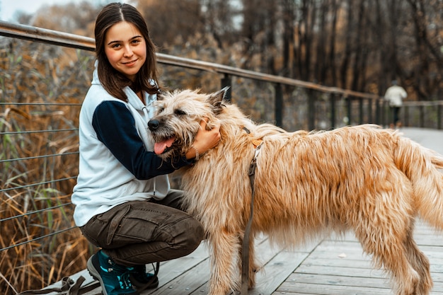 Tiertraining. Ein freiwilliges Mädchen geht mit einem Hund aus einem Tierheim. Mädchen mit einem Hund im Herbstpark