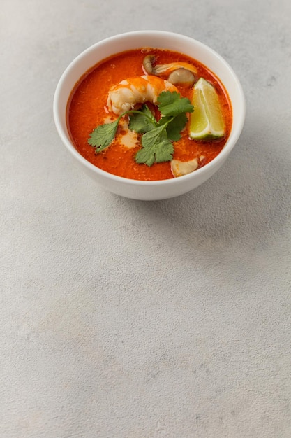 Tigela branca de sopa fresca de Tom Yum em um fundo claro