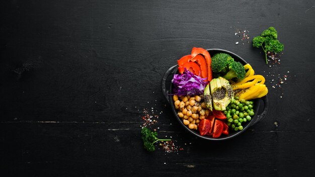 Tigela Buda grão de bico abacate brócolis páprica ervilhas tomates Salada de legumes Vista superior Espaço livre para o seu texto