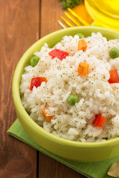 Foto tigela cheia de arroz isolado em madeira