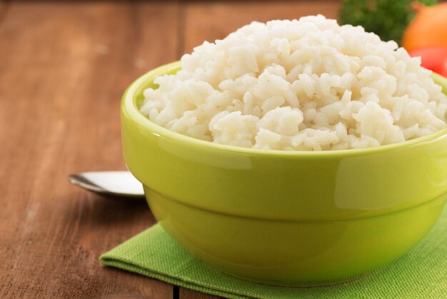 Tigela cheia de arroz isolado em madeira