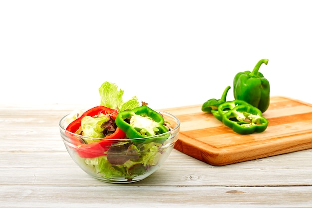 Tigela cheia de salada fresca em um branco de madeira