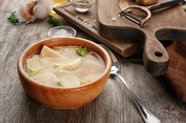 Tigela com caldo saboroso e bolinhos na mesa