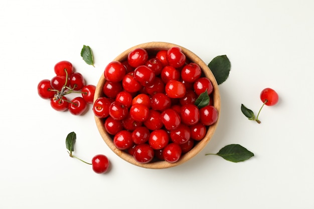 Tigela com cereja vermelha fresca em fundo branco