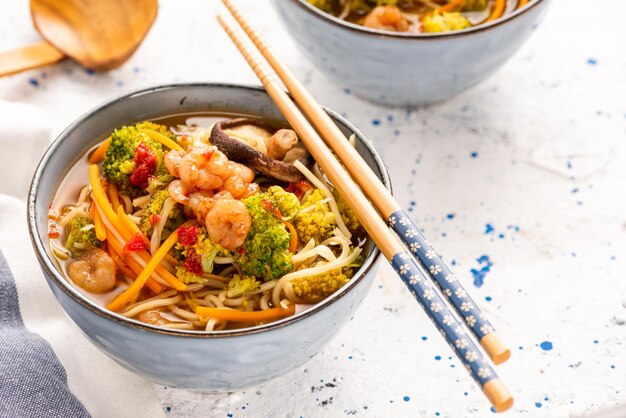 Tigela com macarrão de camarão e legumes dieta saudável sopa na tigela