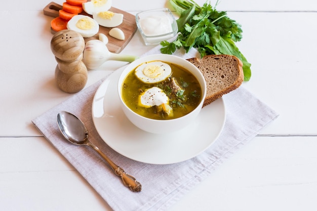 Tigela com perfumada azeda e sopa de urtiga com vitela no vapor e ovo de galinha, creme de leite para melhorar o sabor. Produtos naturais.