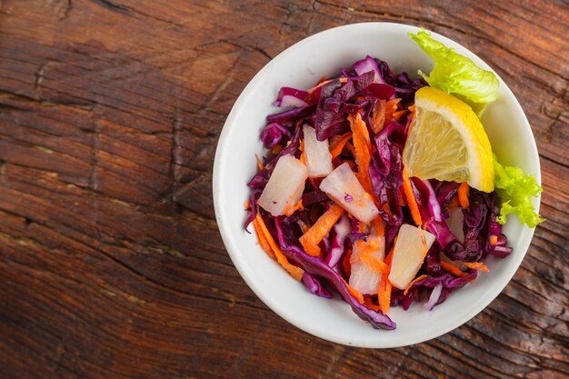 Tigela com salada lenta de cole em um fundo de madeira decorado com ervas. foto horizontal