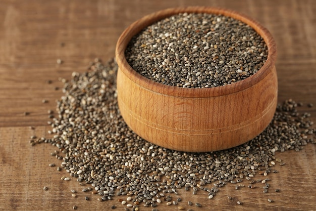 Tigela com sementes de chia na mesa de madeira