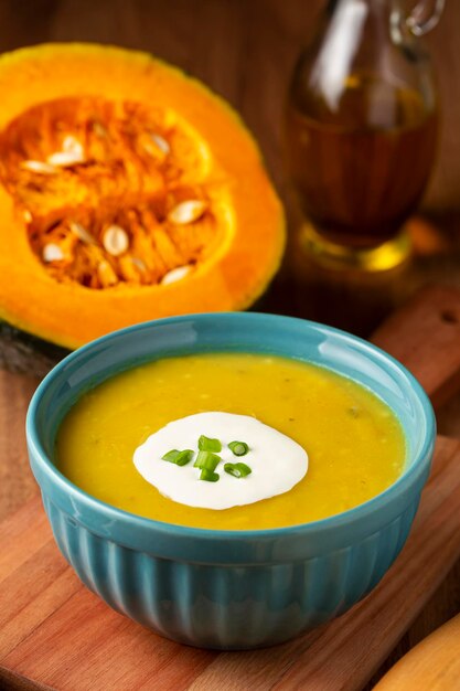 Tigela com sopa de abóbora em cima da mesa.