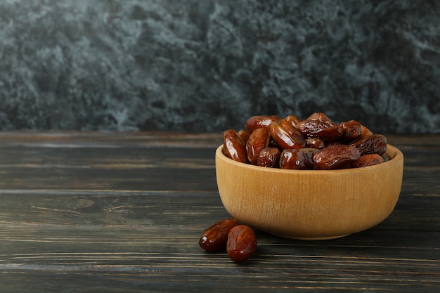 Tigela com tâmaras secas na mesa de madeira