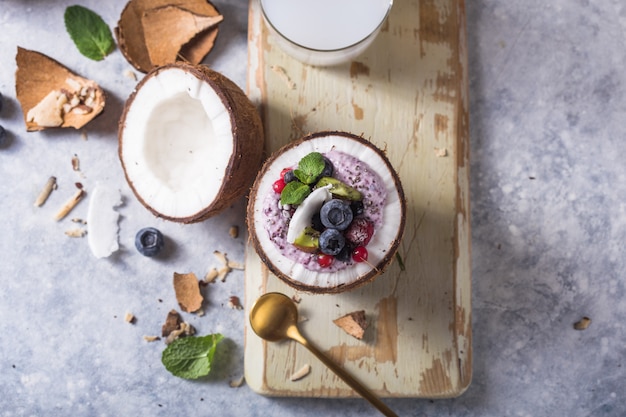 Tigela de açaí saboroso smoothie apetitoso feito de amoras e frutos silvestres. Servido em uma tigela de coco. Vida saudável limpa comer conceito. Creme de sobremesa congelada.